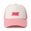 Pink trucker hat with a "Howdy" embroidered patch for western style and everyday wear.